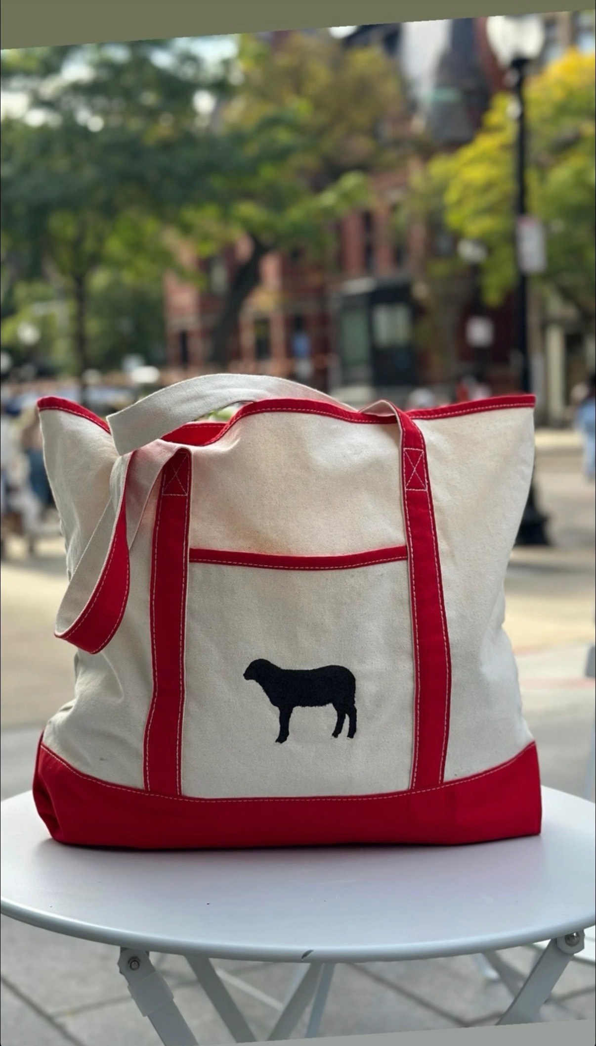 Canvas tote bag with black sheep silhouette and red handles